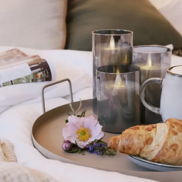 Frühstück im Bett Serviertablett mit Blumen, Croissant und Kerze im Apartment – stimmungsvolle Wohlfühlatmosphäre der WolkenGuckerei.